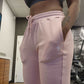 Woman at the gym modeling active-wear brand Sweat or Sparkle Athletics  Gunpowder Gray Sports Bra and Millennial Pink Sweatpants.