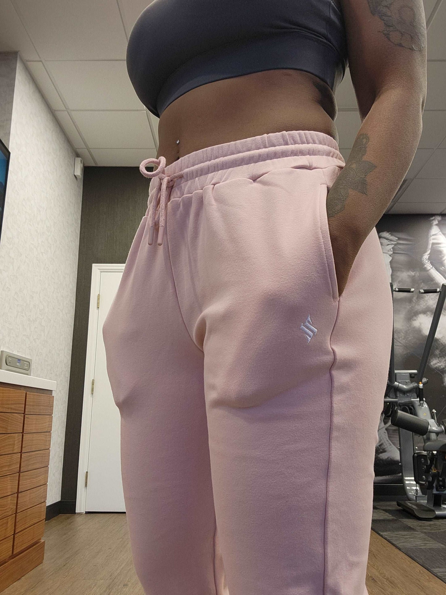 Woman at the gym modeling active-wear brand Sweat or Sparkle Athletics  Gunpowder Gray Sports Bra and Millennial Pink Sweatpants.