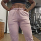 Woman posing at the gym wearing active-wear brand Sweat or Sparkle Athletics Gunpowder Gray Sports Bra and Millennial Pink Sweatpants.