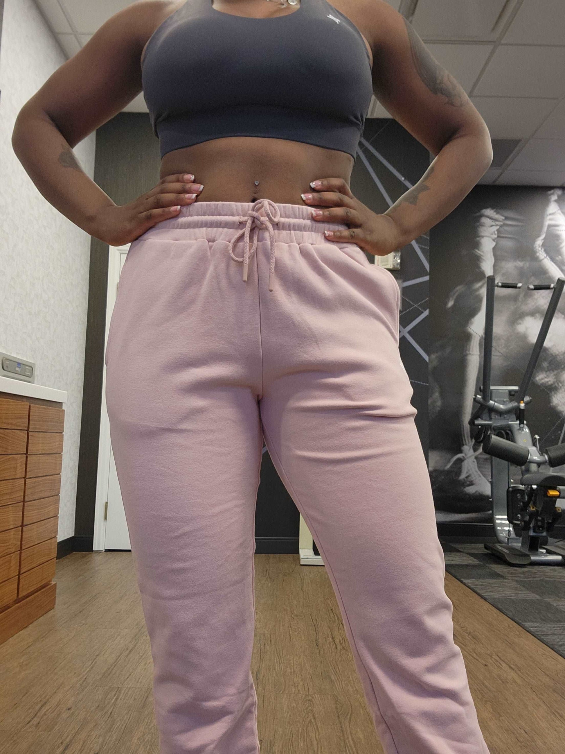 Woman posing at the gym wearing active-wear brand Sweat or Sparkle Athletics Gunpowder Gray Sports Bra and Millennial Pink Sweatpants.