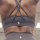 Woman modeling active-wear brand Sweat or Sparkle Athletics Gunpowder Gray Cross-Back Sports Bra.