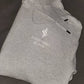 Image of active-wear brand Sweat or Sparkle Athletics Glacier Gray Hoodie folded on a gray blanket.