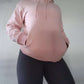 Woman modeling active-wear brand Sweat or Sparkle Athletics Millennial Pink Hooded Sweatshirt.